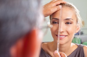woman's face being measured by plastic surgeon