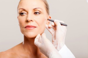 doctor prepping woman for facelift