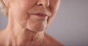 Senior female face with wrinkled skin on face and neck