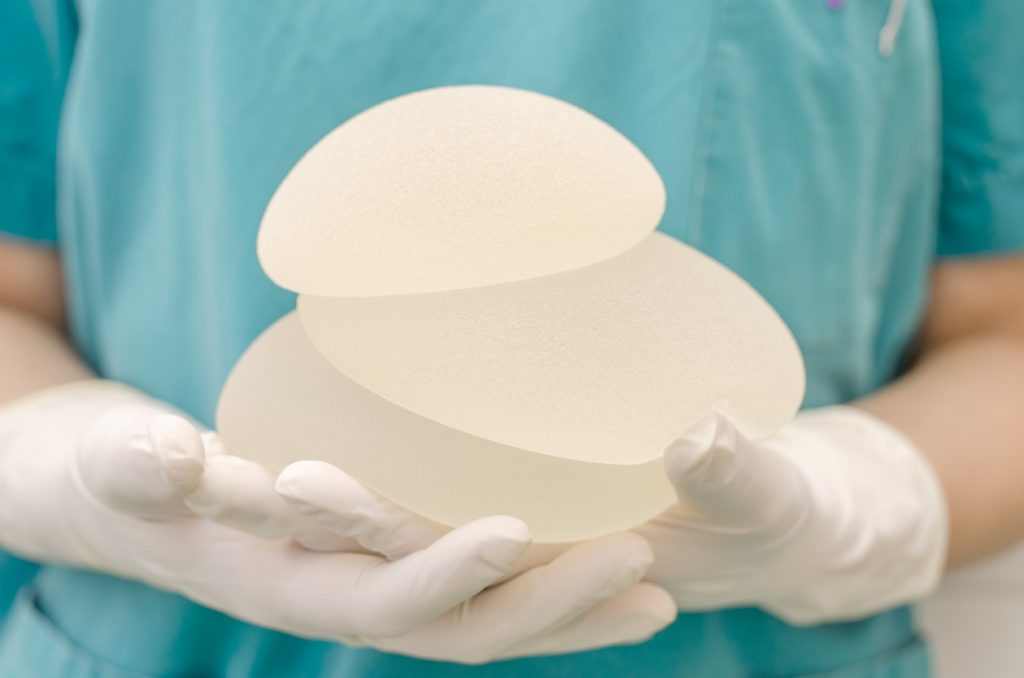Dr. Thomas Loeb holding silicone breast implants