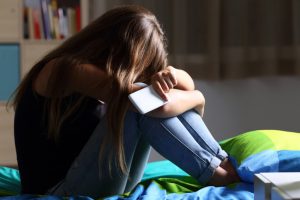 teen girl depressed with cell phone