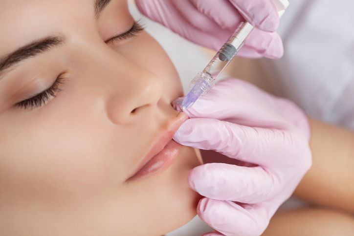 The doctor cosmetologist makes Lip augmentation procedure of a beautiful woman in a beauty salon.Cosmetology skin care.