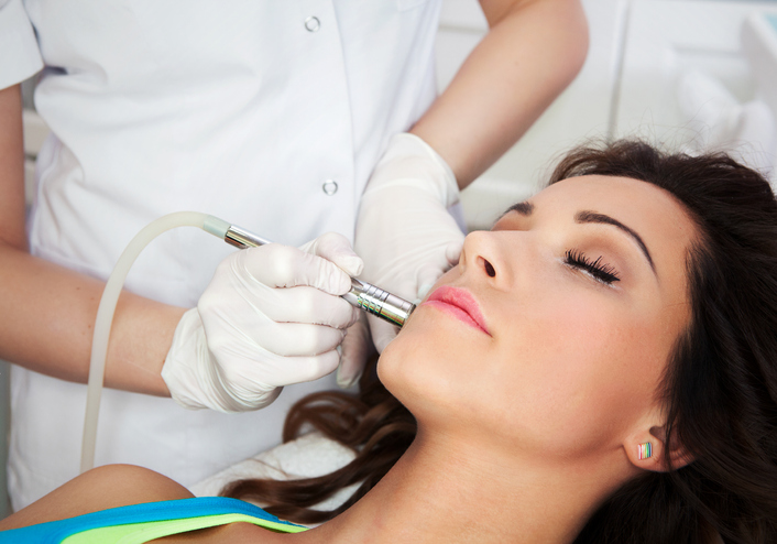 Woman getting laser face treatment in medical spa center, skin rejuvenation concept