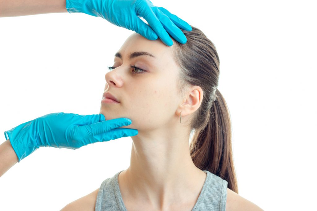 young woman having revision rhinoplasty consultation